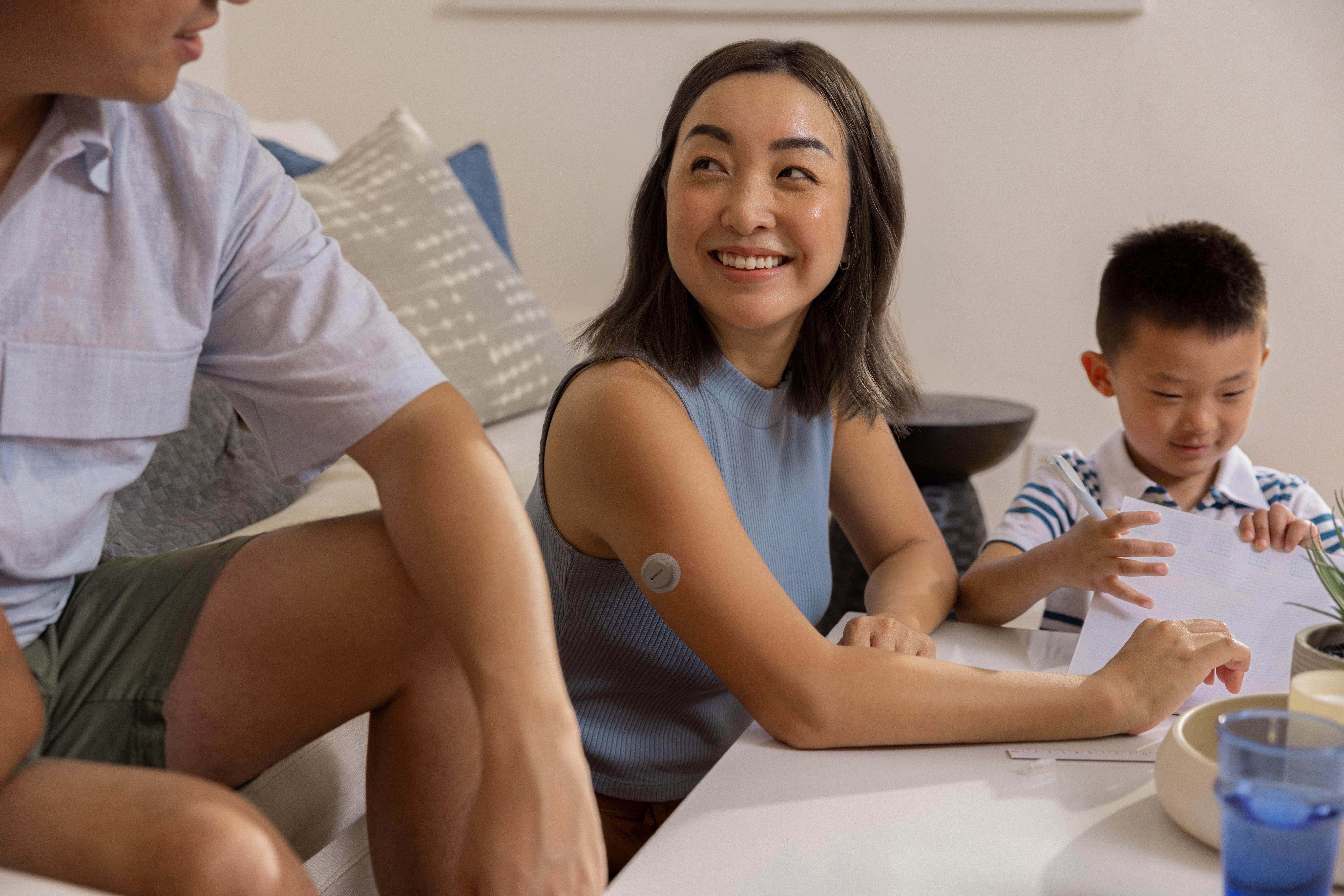 아이와 함께 노는 남편을 보며 웃는 여성